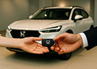 Entrega da chave de um Honda HR-V branco, representando a finalização da contemplação de consórcio Honda.